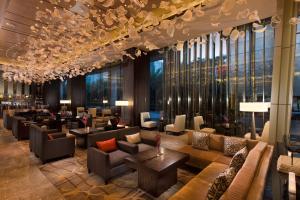 深圳深圳大中华希尔顿酒店（地铁出站即达、近福田会展中心）的酒店大堂设有沙发、桌子和窗户。