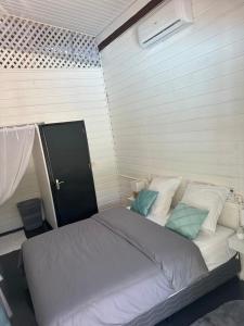 马罗尼河畔圣洛朗Villa REYDISIA的一间卧室配有一张带白色和蓝色枕头的大床