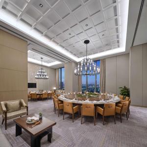 北京北京通州北投希尔顿酒店的用餐室配有桌椅和吊灯。