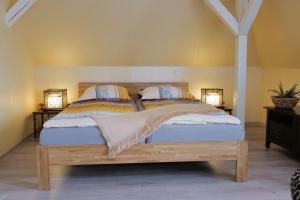 布劳恩费尔斯Elena Kempf Haaratelier & Guesthouse的一间卧室配有一张带两盏灯的木床。