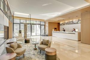 台北台北中山九昱希尔顿逸林酒店的酒店大堂设有两把椅子和柜台