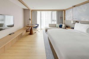台北台北中山九昱希尔顿逸林酒店的酒店客房设有一张大床和一张桌子。