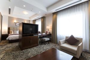 米子市米子市全日空皇冠假日酒店的酒店客房设有电视和床。