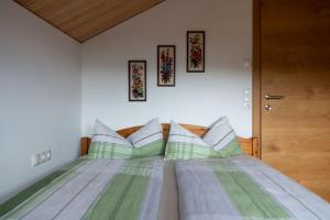 布雷根茨Ferienhaus Bergblick Bregenzerwald的一间卧室配有带绿色和白色枕头的床
