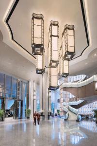 广州广州康莱德酒店的大楼内带自动扶梯和吊灯的大堂