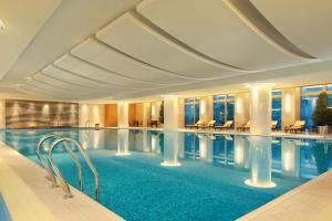 杭州杭州和达希尔顿逸林酒店的酒店的大型游泳池配有桌椅
