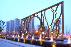 杭州杭州和达希尔顿逸林酒店的一座有灯光的桥梁和一个城市的背景