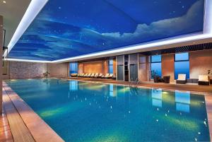芜湖芜湖世茂希尔顿逸林酒店的一座大型游泳池,天花板上画着画