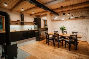 昆塞斯波德安德莱基尼科姆Nebesky 81的厨房以及带木桌和椅子的用餐室。