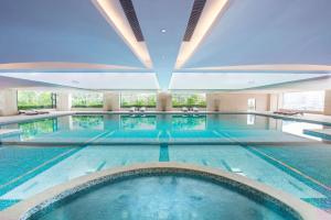 中山中山利和希尔顿酒店的大型室内游泳池,拥有大型天花板