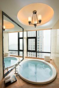 中山中山利和希尔顿酒店的大型浴室设有大窗户和大浴缸。
