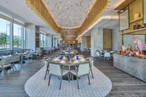 宝安深圳机场希尔顿逸林酒店的用餐室设有桌椅和窗户。