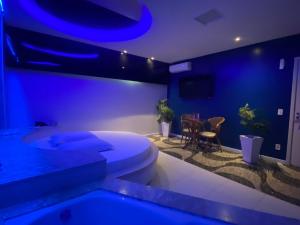 克里西玛Passione Criciúma - Adult Only的蓝色的客房设有卫生间和桌子