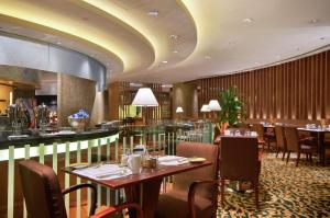 重庆重庆希尔顿酒店的一间带桌椅的餐厅和一间酒吧