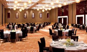 无锡无锡希尔顿逸林酒店的宴会厅配有桌椅和吊灯