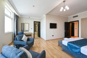 多哈萨雷姆施勒比套房酒店的酒店客房配有一张床、一张沙发和椅子。
