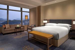 济南济南鲁能希尔顿酒店及公寓 的一间带大床的卧室和一间客厅