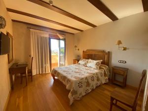 阿尔德亚达维拉德拉里韦拉Hotel Rural Centro de las Arribes的一间卧室配有一张床、一张桌子和一个窗户。