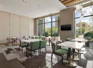 天津天津华苑希尔顿花园酒店的餐厅设有桌椅和平面电视。
