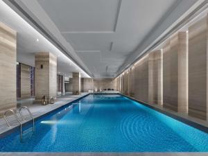 保定保定中博希尔顿逸林酒店的酒店大堂的游泳池,设有大型蓝色游泳池