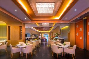宁波宁波春晓世茂希尔顿逸林酒店的一间设有白色桌子和白色椅子的餐厅