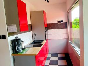 新瓦尔普诺holiday home, Nowe Warpno的一个带红色橱柜和水槽的小厨房