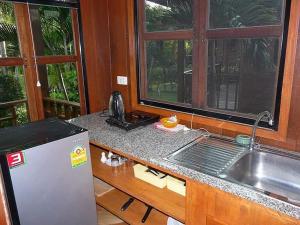 Ban Nong Chap TaoBangsaray Village Resort的带水槽的厨房台面和窗户