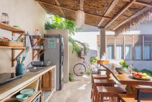 图卢姆Hostal Doña Lucha的厨房配有冰箱和木制桌椅