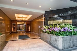 曼谷曼谷港丽公寓酒店的种植园内鲜花盛开的酒店大厅