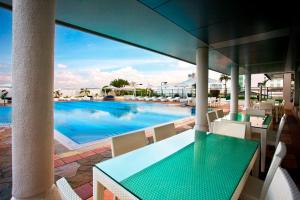 科伦坡科伦坡希尔顿酒店式公寓的一个带桌椅的庭院和一个游泳池