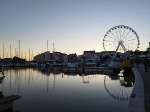 阿格德角Appartement centre port Cap d'Agde的船轮坐在码头旁边,有水
