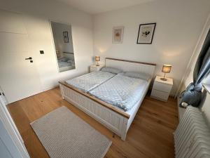 石勒苏益格Wiking Yachthafen - Schleiblick的一间卧室配有一张带2个床头柜和镜子的床