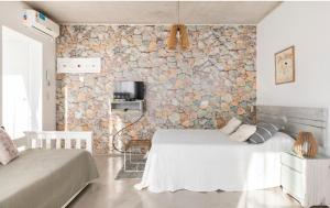 Remedios de EscaladaLuminoso y comfortable monoambienteA 25 minutos de Ezeiza的一间卧室设有两张床和石墙