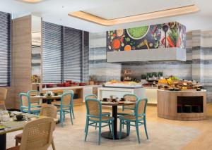雅加达Hilton Garden Inn Jakarta Taman Palem的厨房以及带桌椅的用餐室。