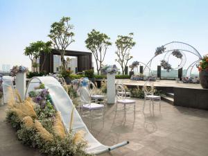 雅加达Hilton Garden Inn Jakarta Taman Palem的一个带滑梯、椅子和鲜花的花园