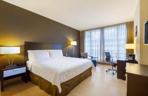 巴拿马城Holiday Inn Panama Distrito Financiero, an IHG Hotel的酒店客房设有一张大床和一张书桌。