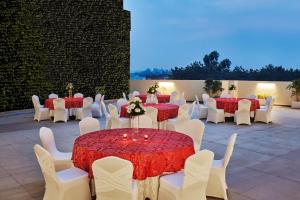 勒克瑙勒克瑙希尔顿花园酒店的一套桌椅,上面有红白的桌布
