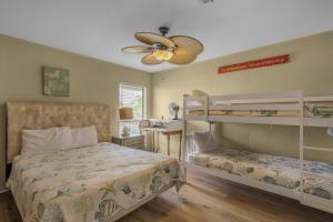 格尔夫海岸Sail House East by Vacation Homes Collection的一间卧室设有两张双层床和吊扇