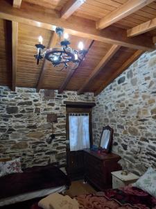 戈伊什Ceira Cottage的一间卧室设有石墙和吊灯。
