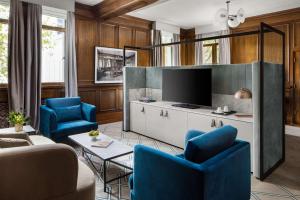 墨尔本Hilton Melbourne Little Queen Street的客厅配有蓝色椅子和电视
