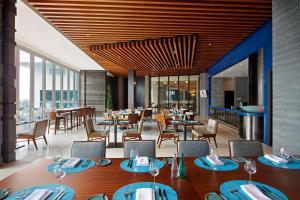 马六甲马六甲希尔顿逸林酒店的餐厅设有桌椅和窗户。