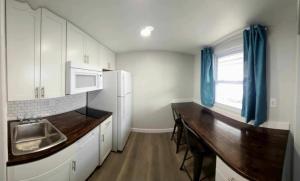 萨拉托加Snowy Mountain Inn的厨房配有白色橱柜和木制台面