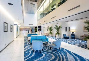 黄金海岸Hilton Surfers Paradise Hotel & Residences的大堂设有蓝色的沙发和椅子,铺着地毯