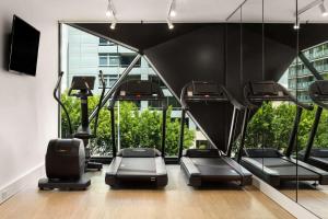 悉尼悉尼西部古玩系列希尔顿酒店的健身房设有黑色椅子和大窗户