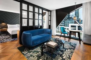 悉尼悉尼西部古玩系列希尔顿酒店的客厅配有蓝色椅子和蓝色沙发