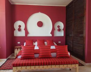 米多恩Dar Amphora Menzel的一间卧室设有红色的墙壁和一张带红色枕头的床