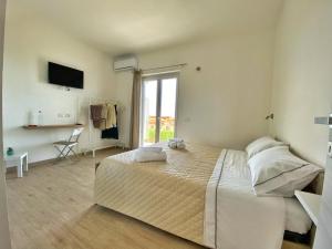 特罗佩阿Campus Dei - Tropea Rooms的一间卧室设有一张大床和一个窗户。