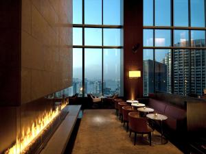 东京东京康莱德酒店的餐厅设有桌椅和大窗户。