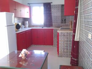 米多恩Dar Amphora Menzel的一间厨房,配有红色橱柜和台面