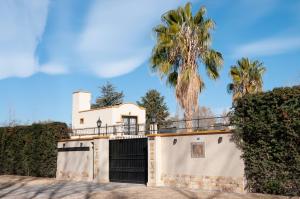 Las CompuertasLa Moni的一座带大门和棕榈树的房子